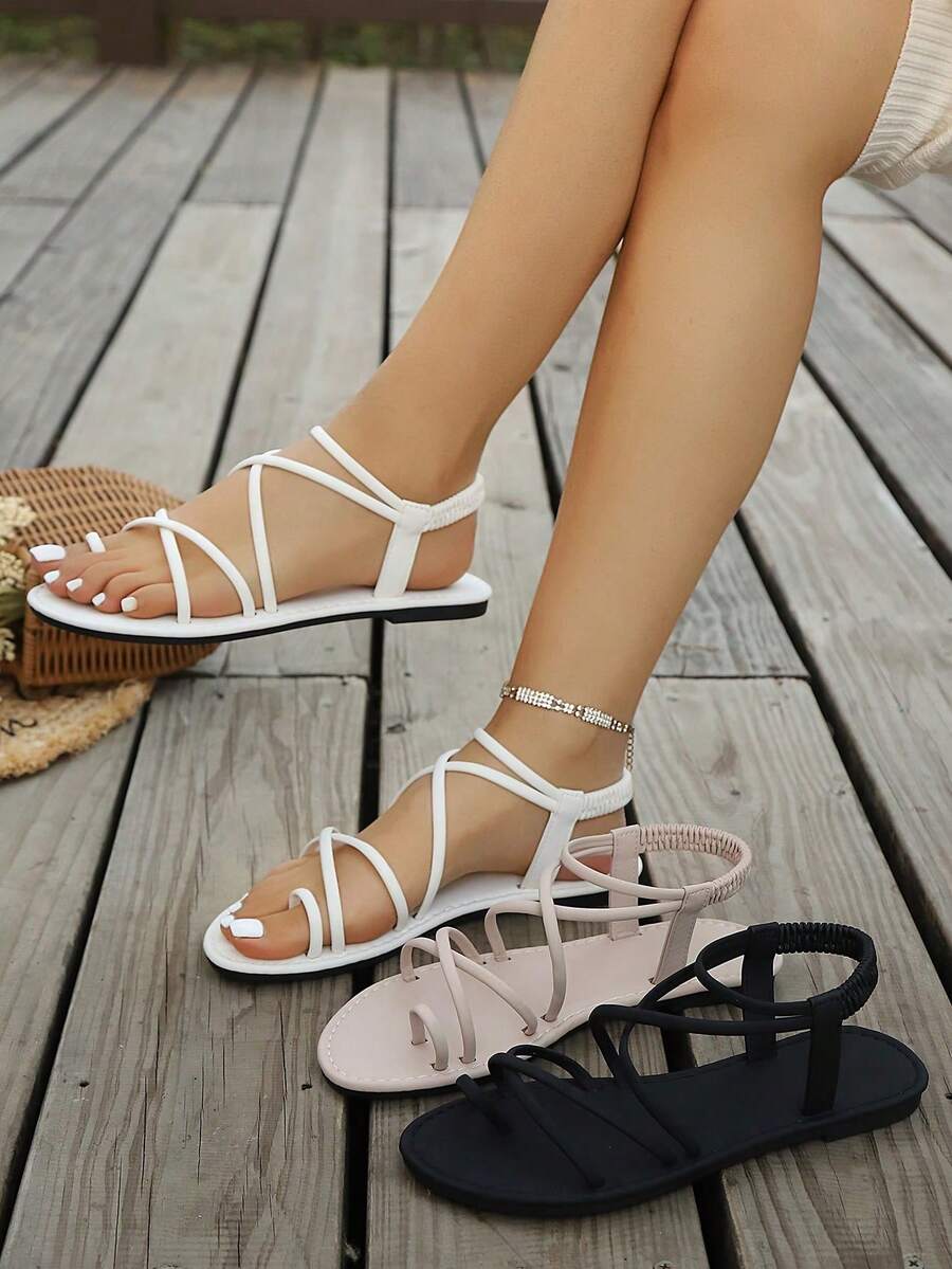 Women's lace-up flat slip-on sandals with round toe and hollow-out PU leather straps for beach and daily wear.