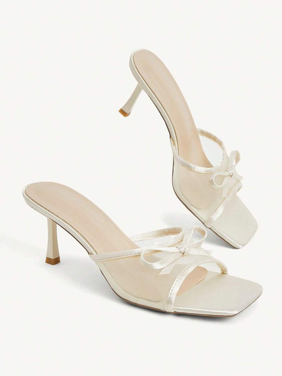 Pair of women's open toe stiletto heeled sandals crafted in satin with a bow accent