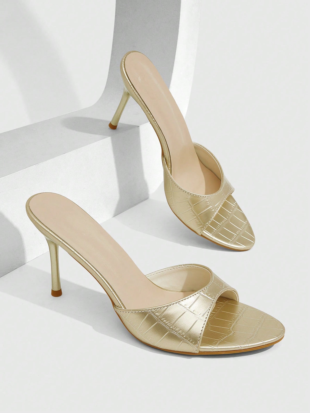 Elegant women's pointed toe heeled sandals with textured pattern and sleek stiletto heel