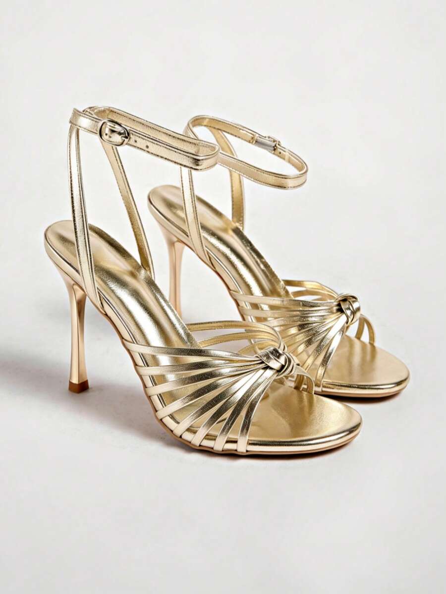 Women's open toe stiletto high heel sandals featuring metallic knot decor and an adjustable ankle buckle strap.
