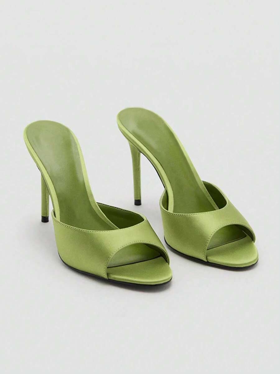 Pair of women's open toe patent leather mule shoes with sleek stiletto heels and cut-out styling