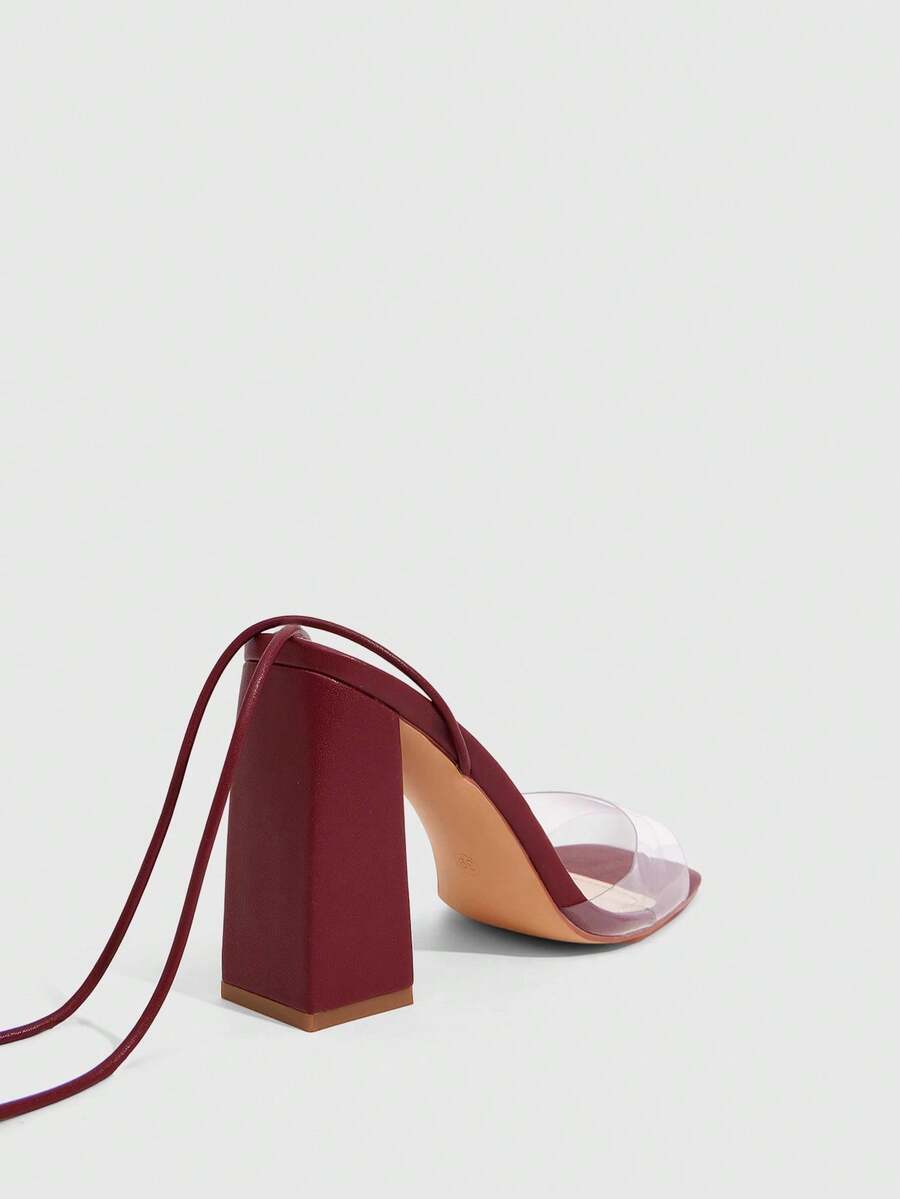 Women's criss-cross lace-up chunky high heel sandals with open square toe and strappy design.