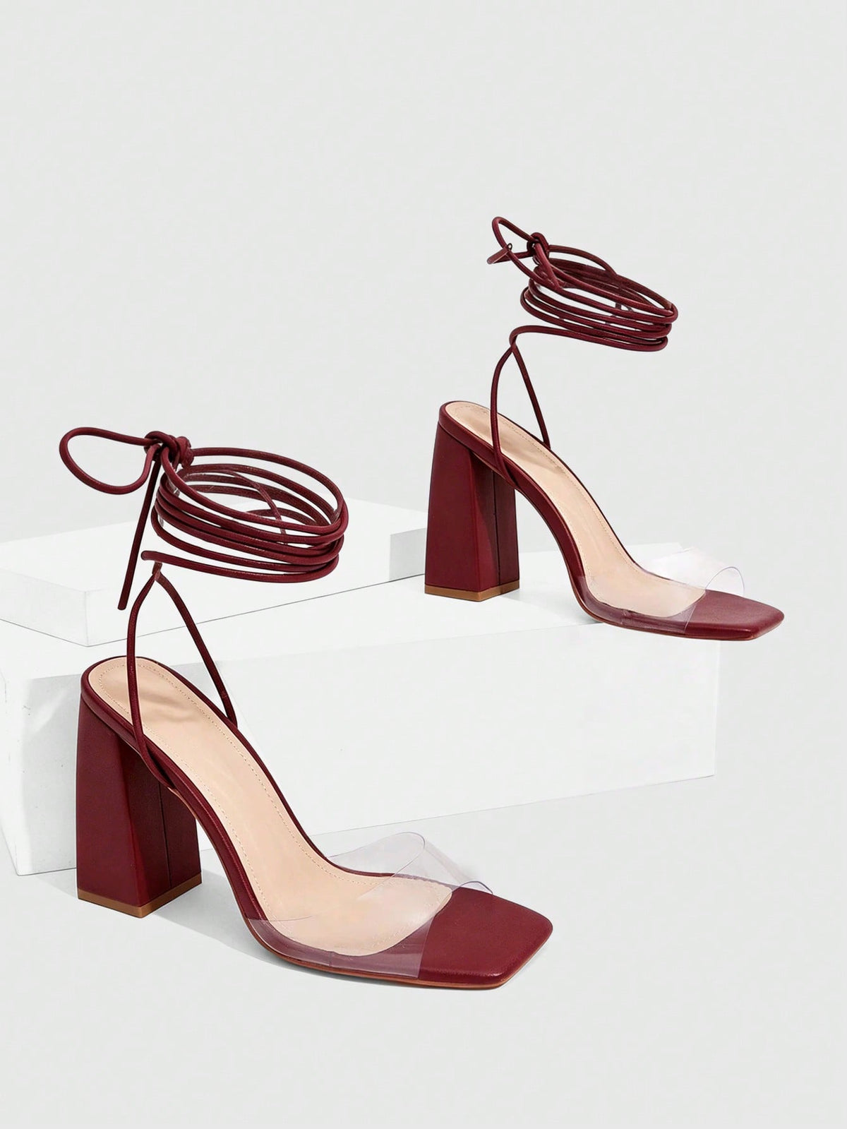 Women's criss-cross lace-up chunky high heel sandals with open square toe and strappy design.