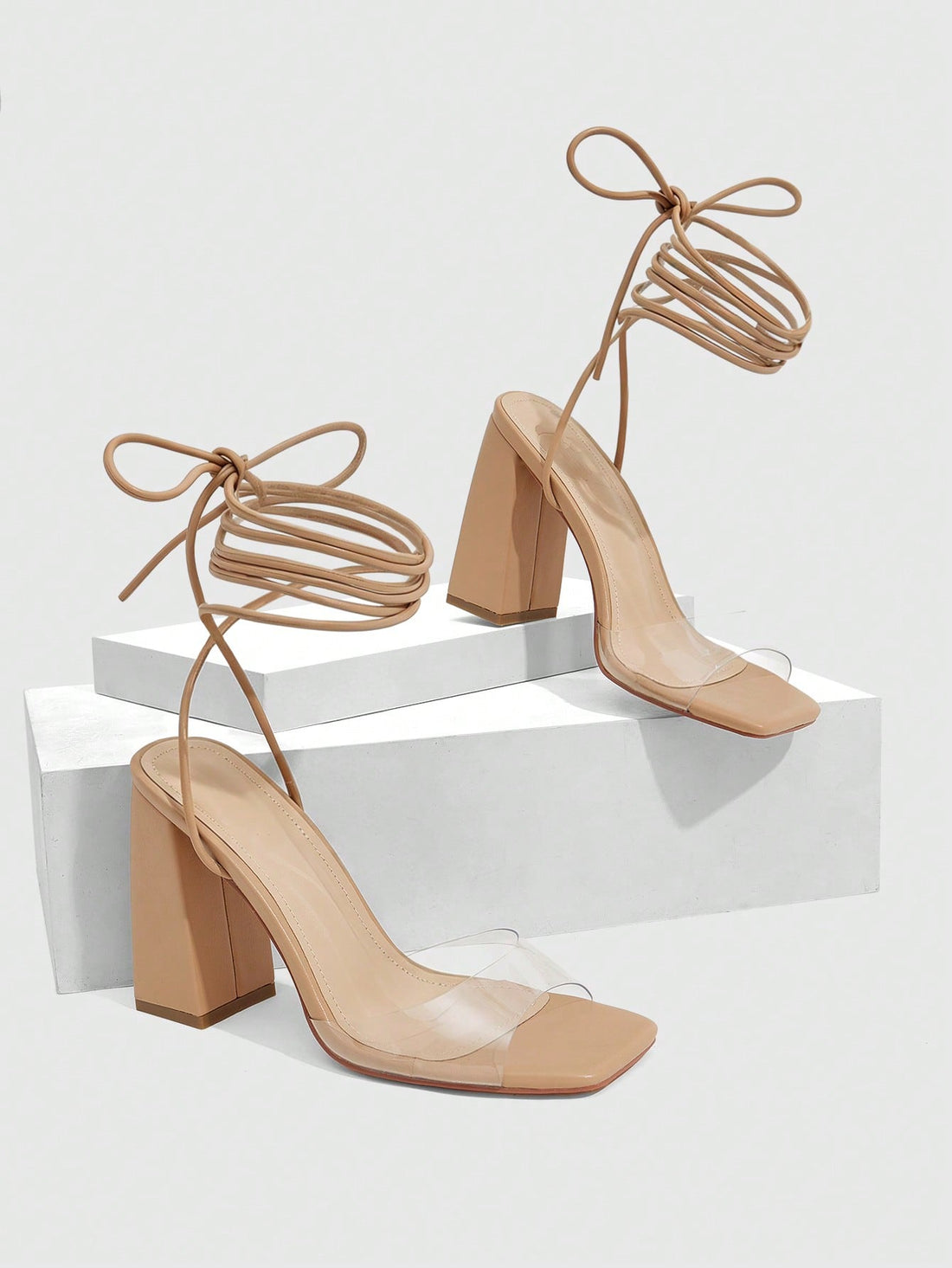 Women's criss-cross lace-up chunky high heel sandals with open square toe and strappy design.