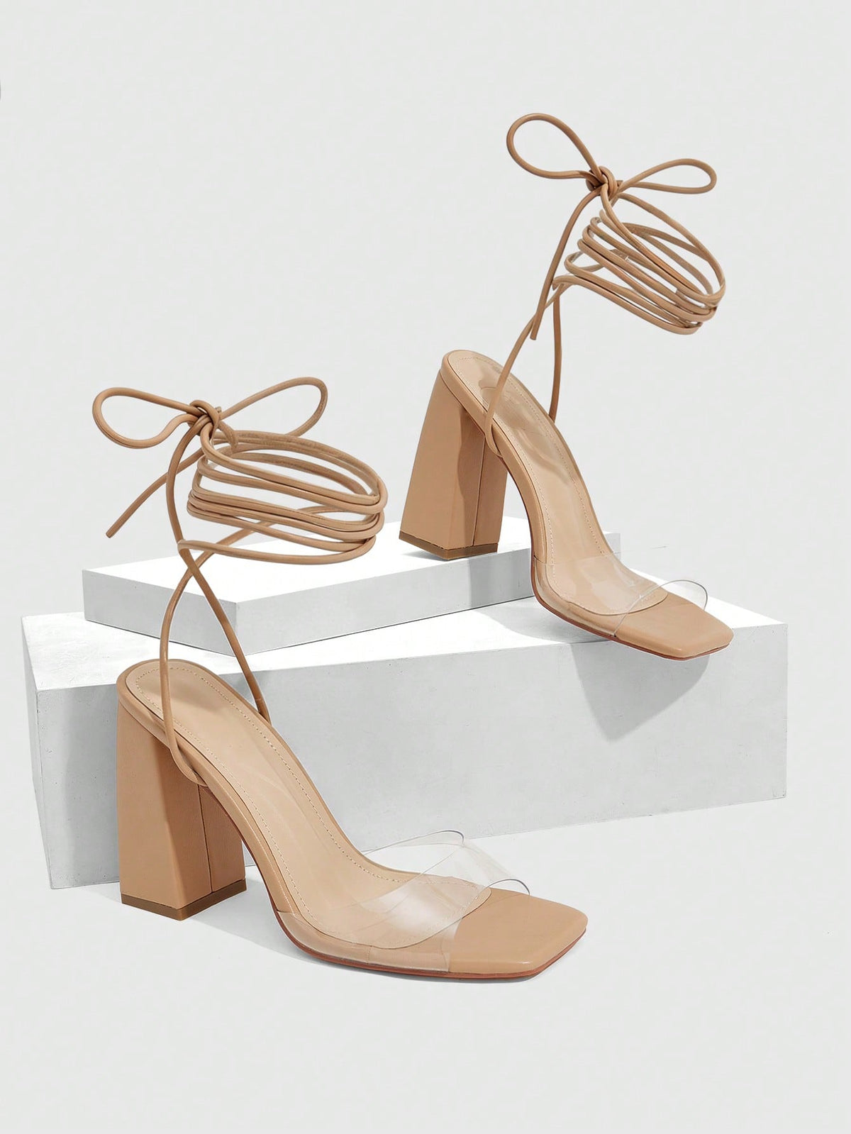 Women's criss-cross lace-up chunky high heel sandals with open square toe and strappy design.