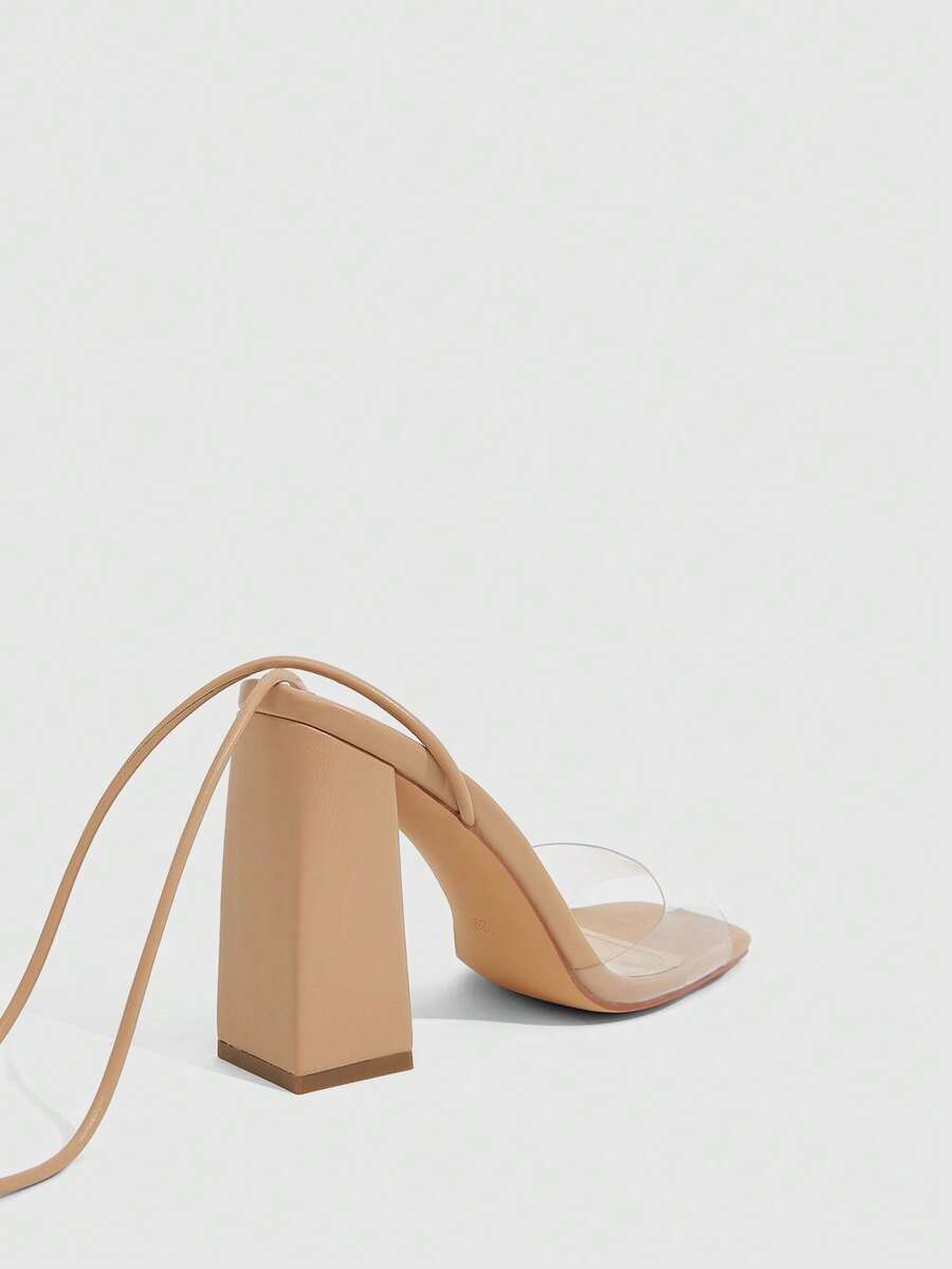 Women's criss-cross lace-up chunky high heel sandals with open square toe and strappy design.