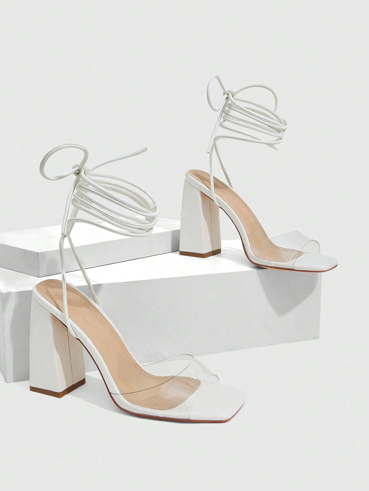Women's criss-cross lace-up chunky high heel sandals with open square toe and strappy design.