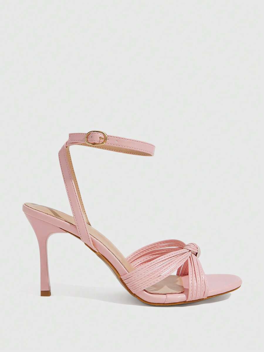Women's champagne stiletto high heel sandals featuring knotted cross-over straps, open round toe, and adjustable ankle buckle strap.