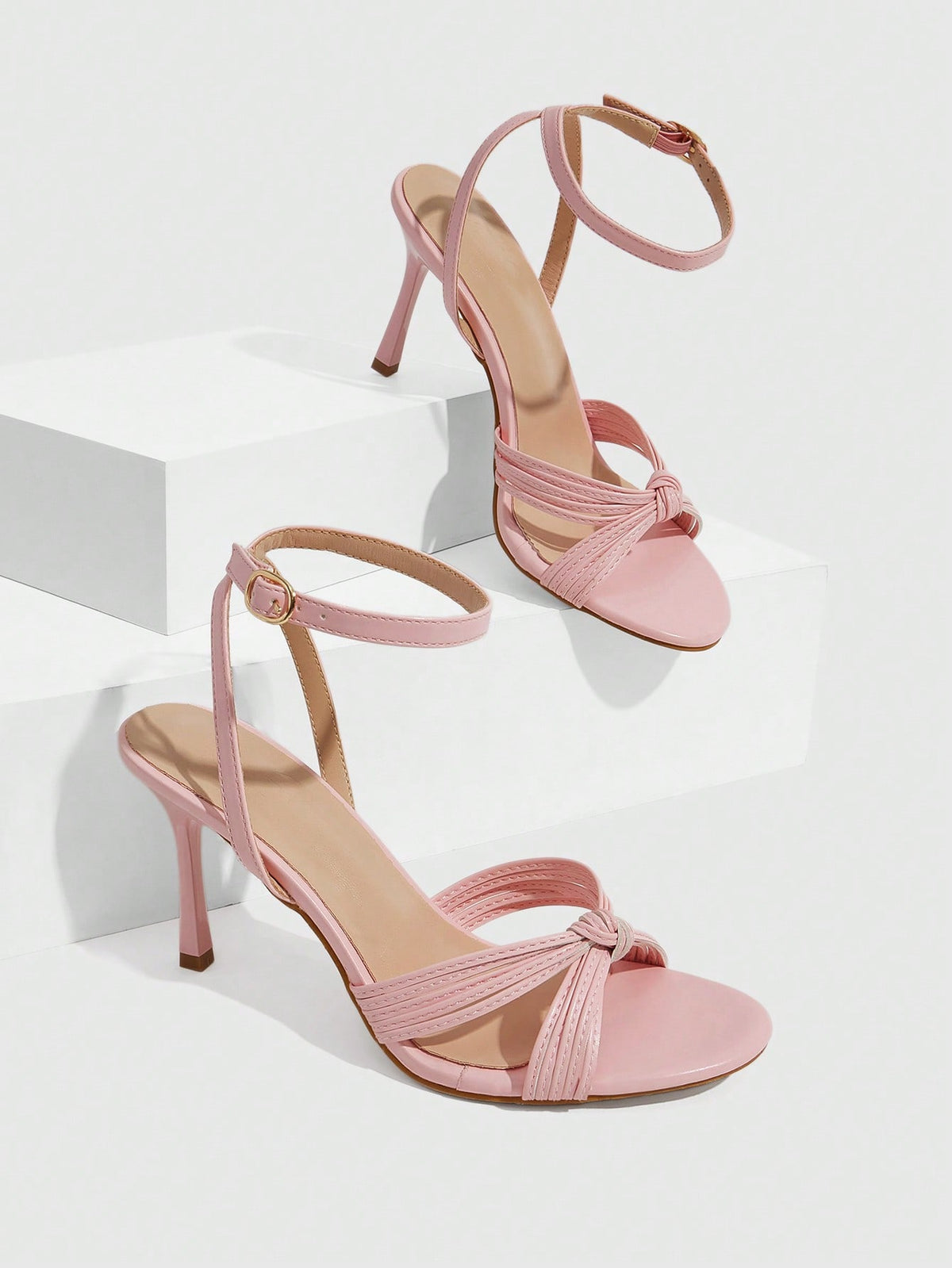 Women's champagne stiletto high heel sandals featuring knotted cross-over straps, open round toe, and adjustable ankle buckle strap.