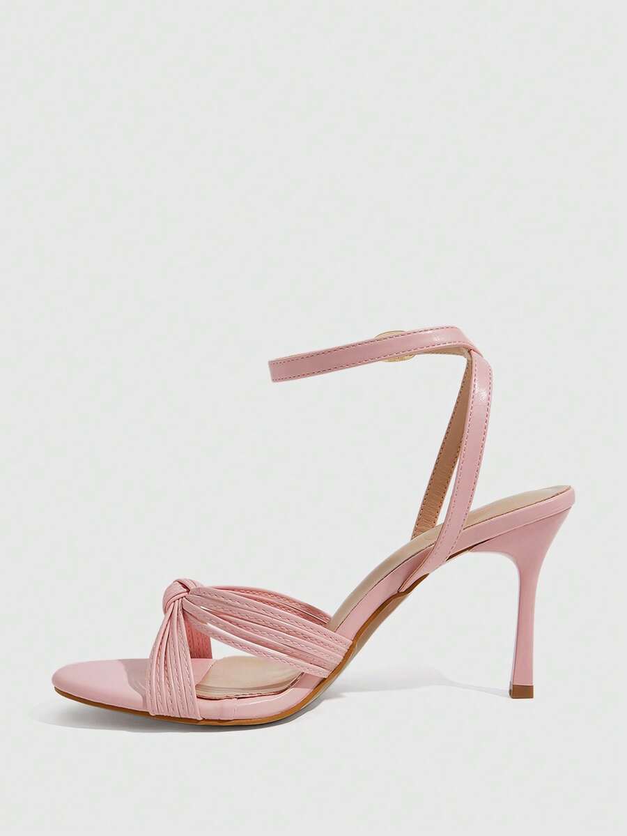Women's champagne stiletto high heel sandals featuring knotted cross-over straps, open round toe, and adjustable ankle buckle strap.