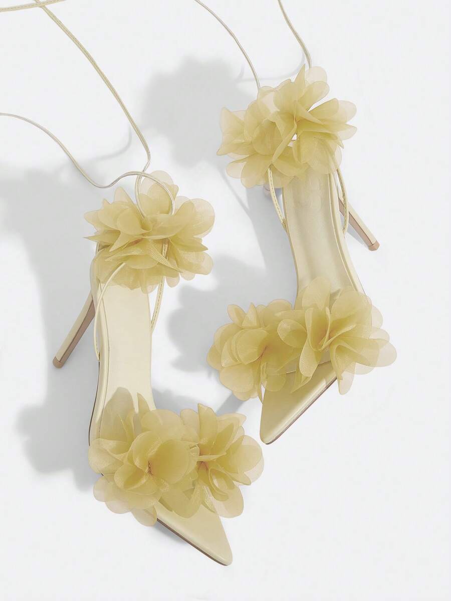 Women's open toe heeled sandals featuring 3D floral decor, satin lace-up ankle straps, and stiletto high heels.