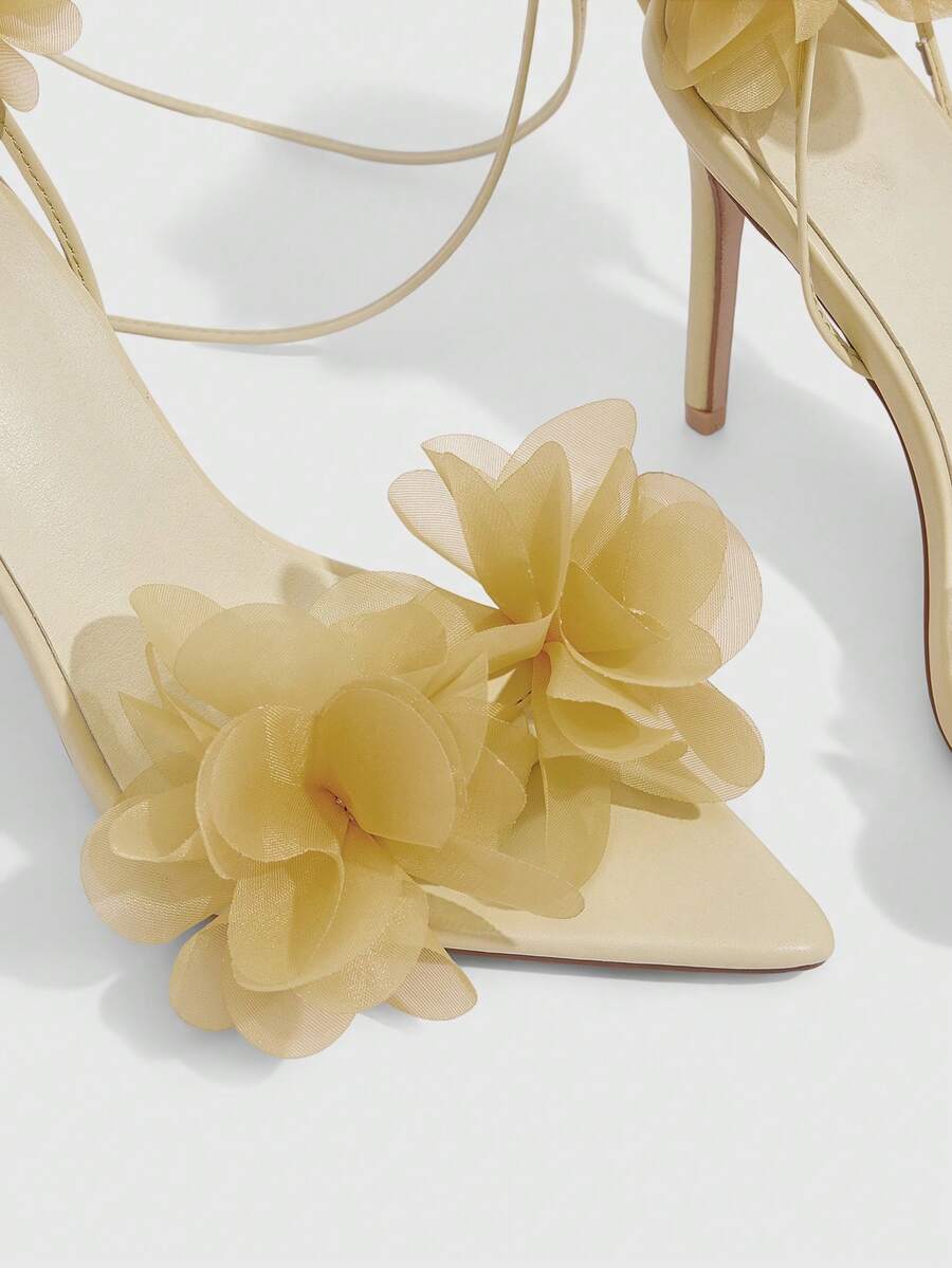 Women's open toe heeled sandals featuring 3D floral decor, satin lace-up ankle straps, and stiletto high heels.