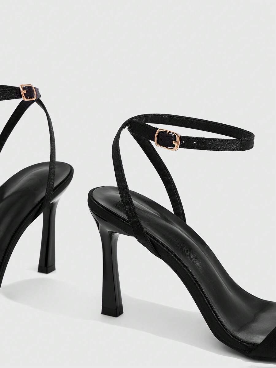 Women's high heel ankle strap sandals with open toe and stiletto heel in mirror black finish.