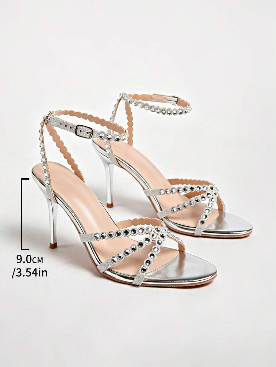Women's open toe stiletto high heel sandals featuring metallic knot decor and an adjustable ankle buckle strap.