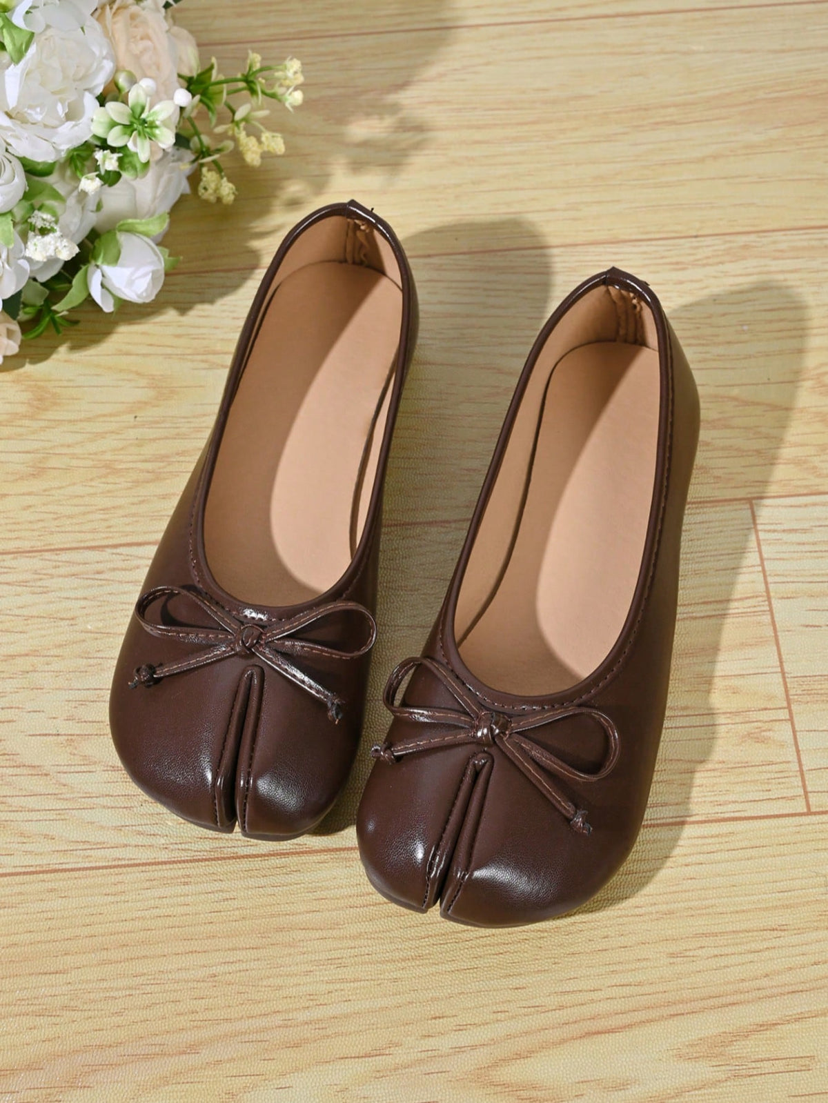 Women's white split-toe slip-on flat shoes with braided accent and rubber sole
