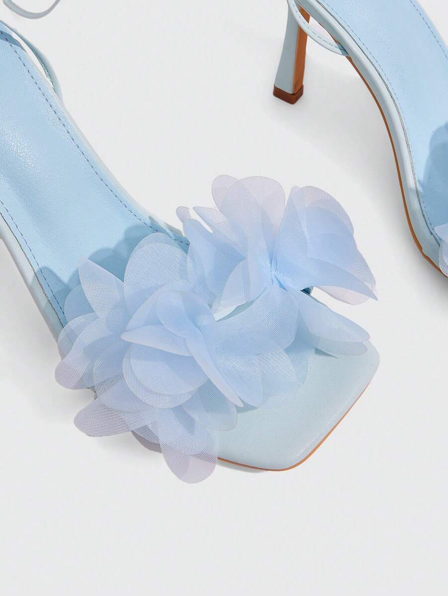 Women's open toe heeled sandals featuring 3D floral decor, satin lace-up ankle straps, and stiletto high heels.
