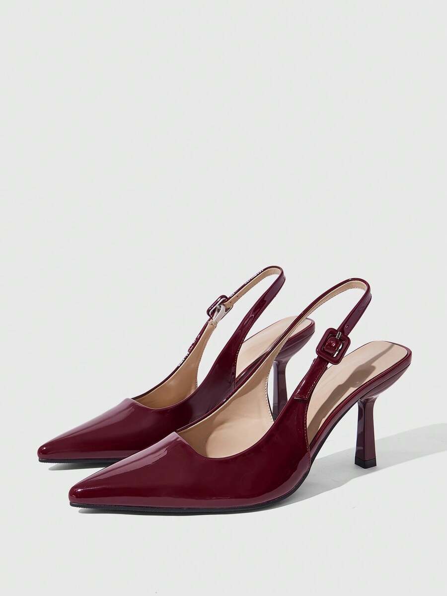 Women's pointed-toe high heel pumps in black mirror PU leather with an ankle strap, stiletto heel, and rhinestone buckle.