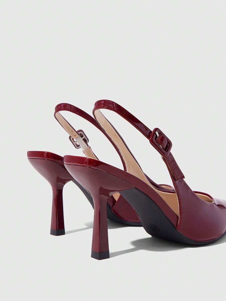 Women's pointed-toe high heel pumps in black mirror PU leather with an ankle strap, stiletto heel, and rhinestone buckle.