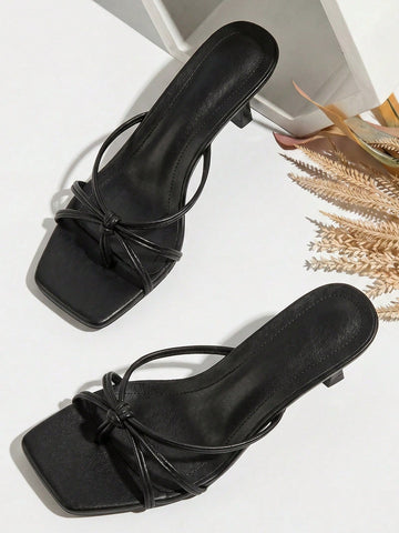 Women's slip-on mule heel sandals featuring knotted criss-cross strappy thong design, square open toe, and mid kitten heel.