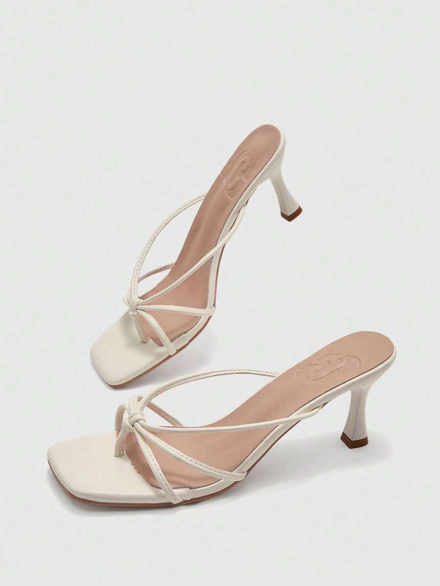Square toe stiletto heel thong sandals for women featuring thin toe post strap, knot detail, and mid pyramid heel.