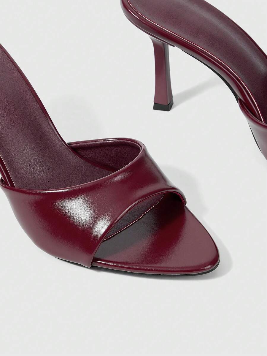 Women's high-heeled slippers in PU leather featuring an open plain toe, belt detail, and stiletto high heel with TPR outsole.