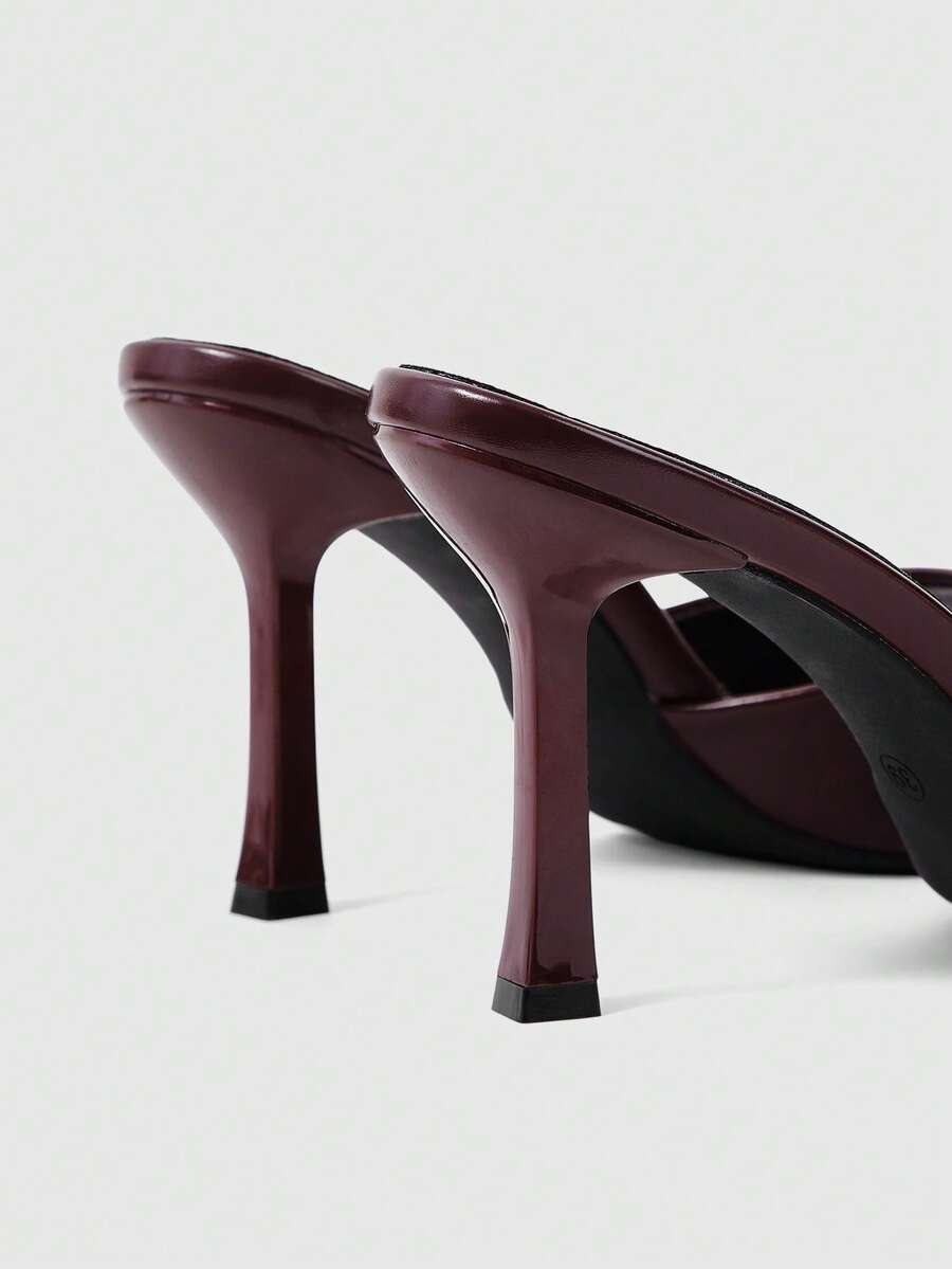 Women's high-heeled slippers in PU leather featuring an open plain toe, belt detail, and stiletto high heel with TPR outsole.