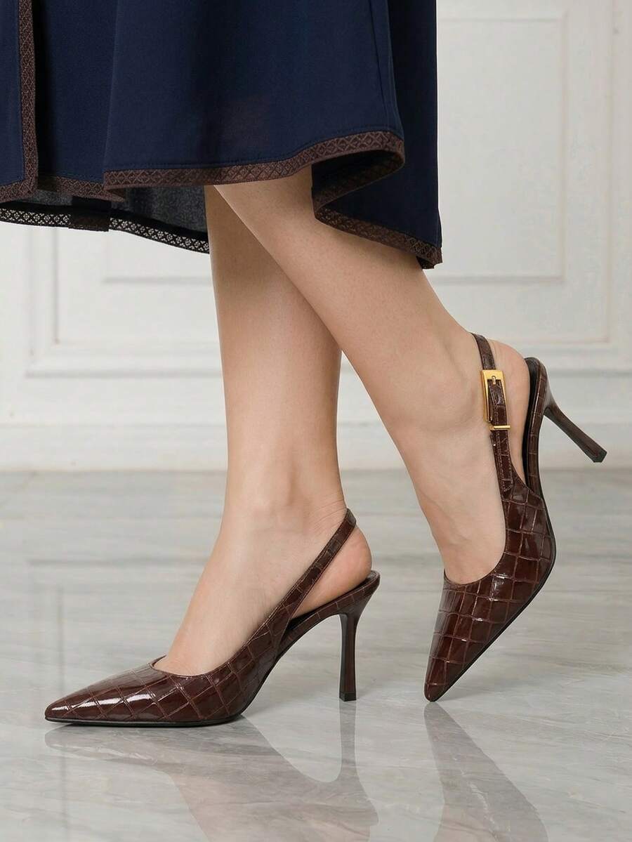 Women's pointed-toe high heel pumps in black mirror PU leather with an ankle strap, stiletto heel, and rhinestone buckle.