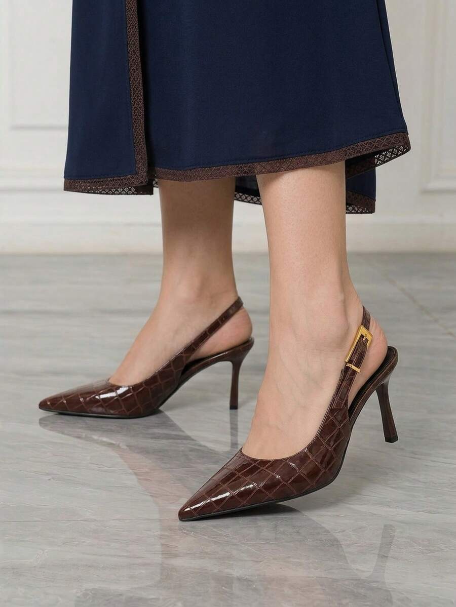 Women's pointed-toe high heel pumps in black mirror PU leather with an ankle strap, stiletto heel, and rhinestone buckle.