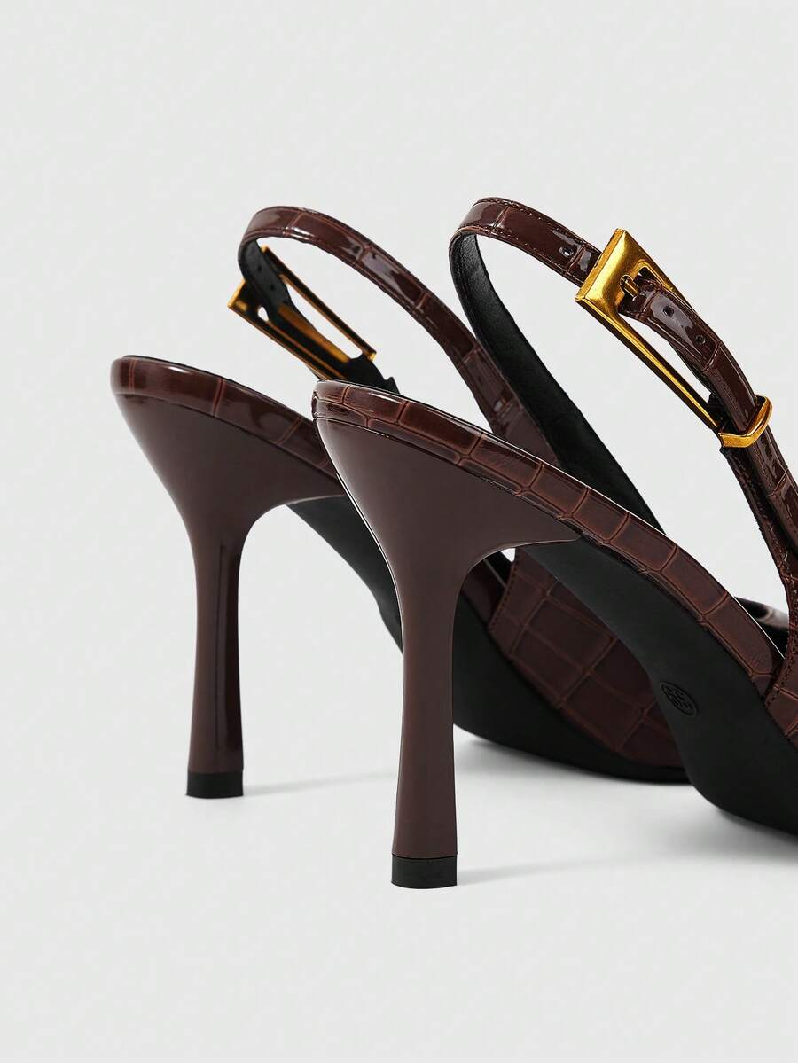 Women's pointed-toe high heel pumps in black mirror PU leather with an ankle strap, stiletto heel, and rhinestone buckle.