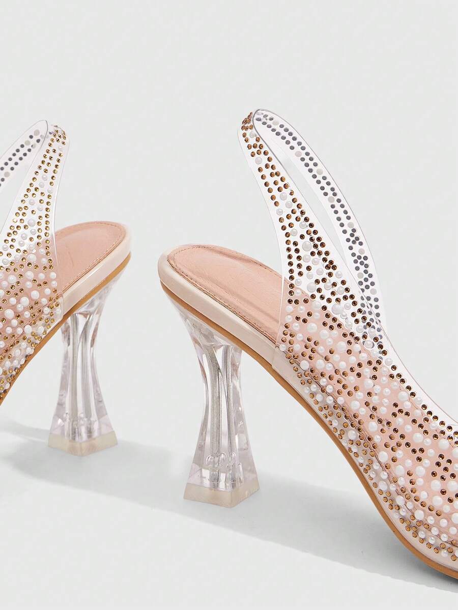 Women's square toe heeled sandals with clear straps, sparkling rhinestone embellishments, and a high pyramid heel.