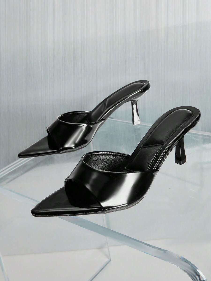 Black pointy toe kitten heel shoes for women featuring a sleek cut out mule design and glossy patent leather finish.