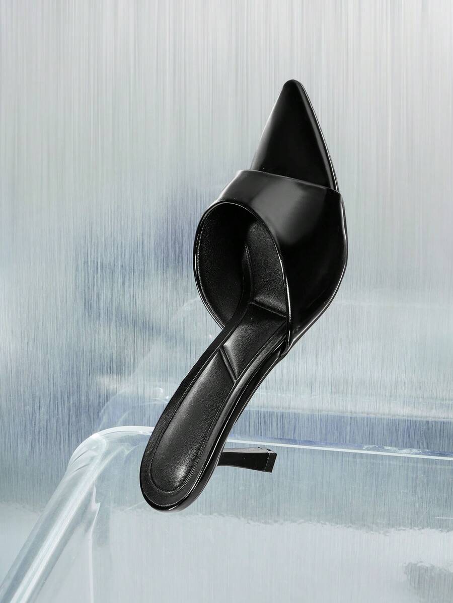 Black pointy toe kitten heel shoes for women featuring a sleek cut out mule design and glossy patent leather finish.