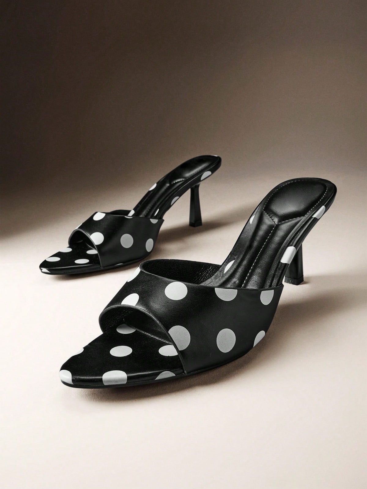 Pair of women's minimalist black pointy toe stiletto heel sandals with slingback straps.