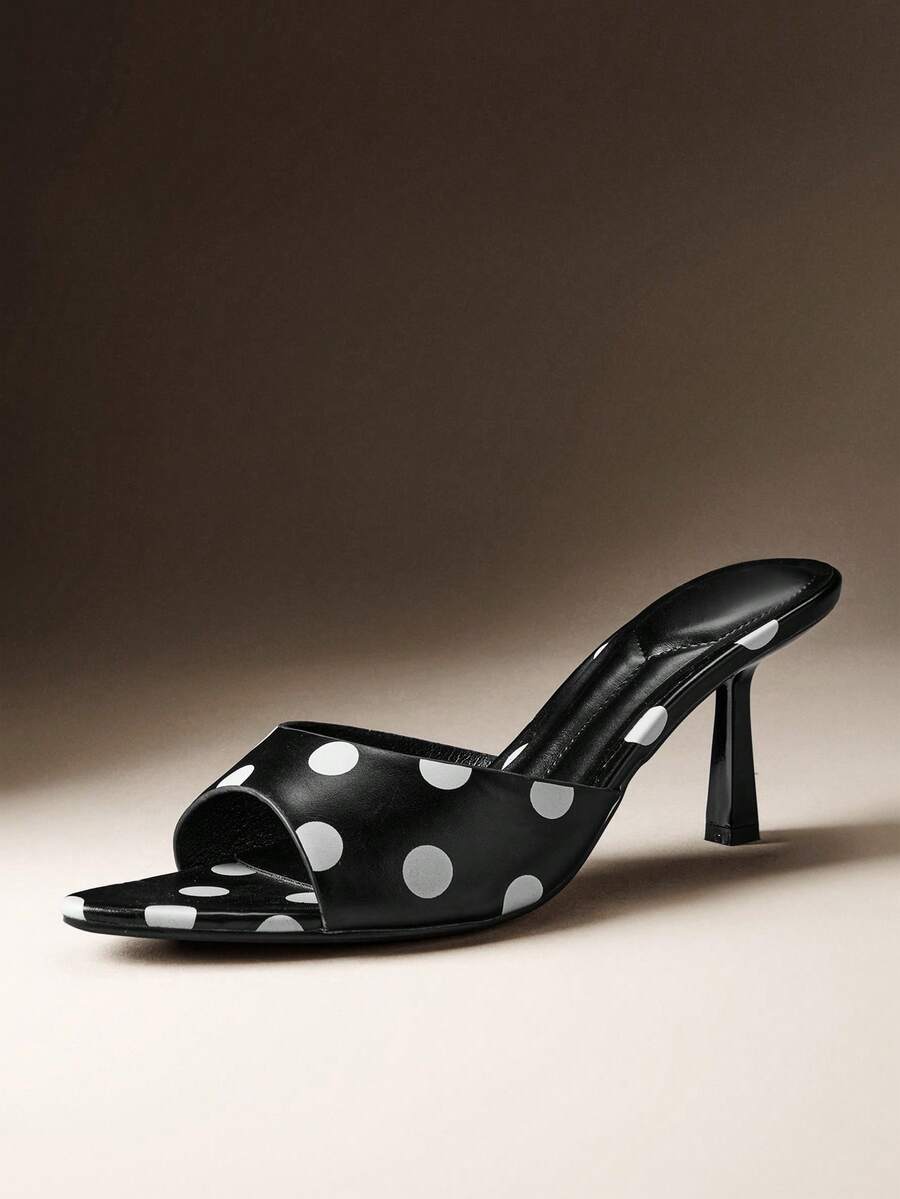 Pair of women's minimalist black pointy toe stiletto heel sandals with slingback straps.