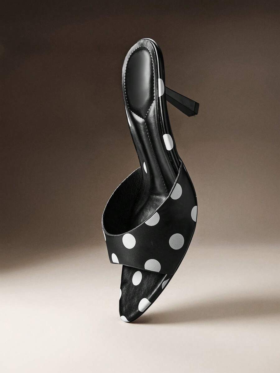 Pair of women's minimalist black pointy toe stiletto heel sandals with slingback straps.