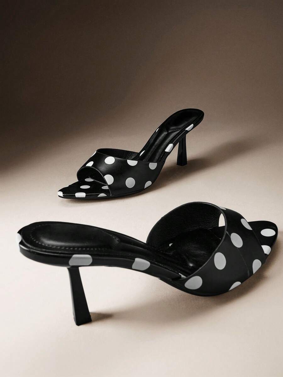Pair of women's minimalist black pointy toe stiletto heel sandals with slingback straps.