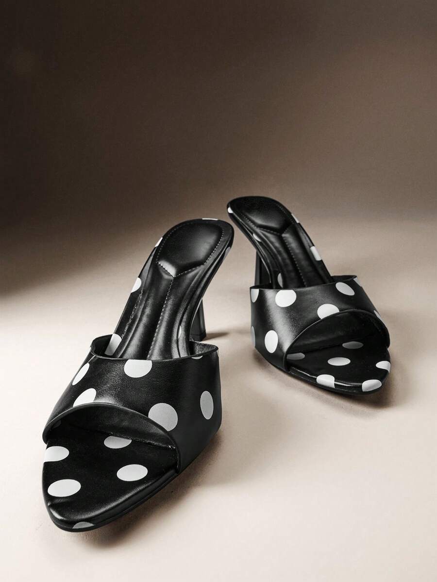 Pair of women's minimalist black pointy toe stiletto heel sandals with slingback straps.