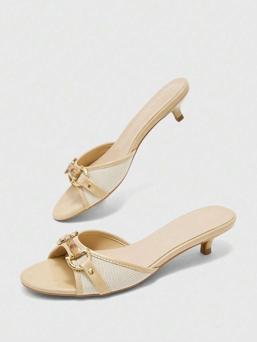 Beige women's slip-on kitten heel slide sandals featuring an accent buckle with grommet eyelets.