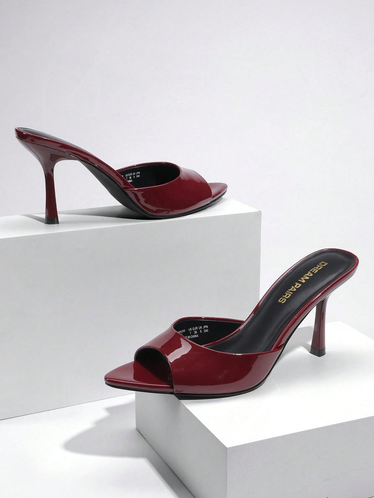 Women's pointed peep toe high heel sandals featuring a sleek stiletto heel, slip-on mule design, and smooth faux leather finish.
