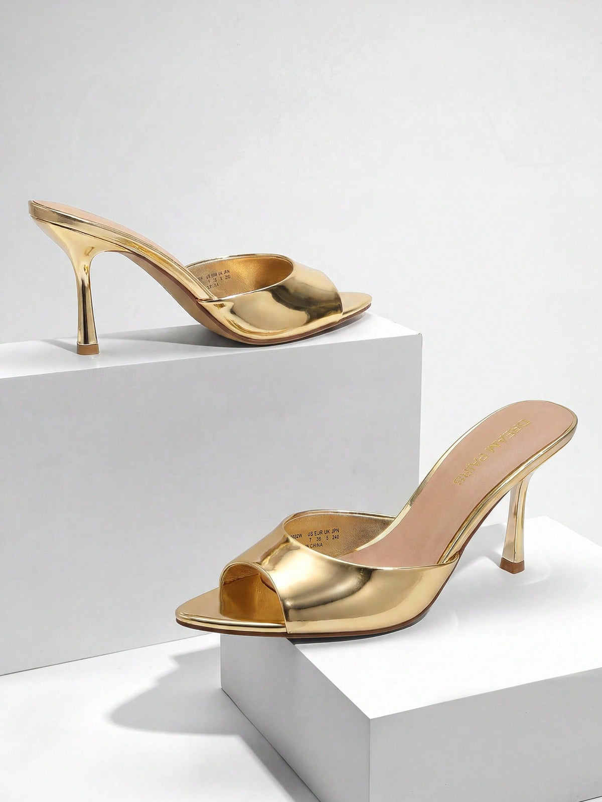 Women's pointed peep toe high heel sandals featuring a sleek stiletto heel, slip-on mule design, and smooth faux leather finish.