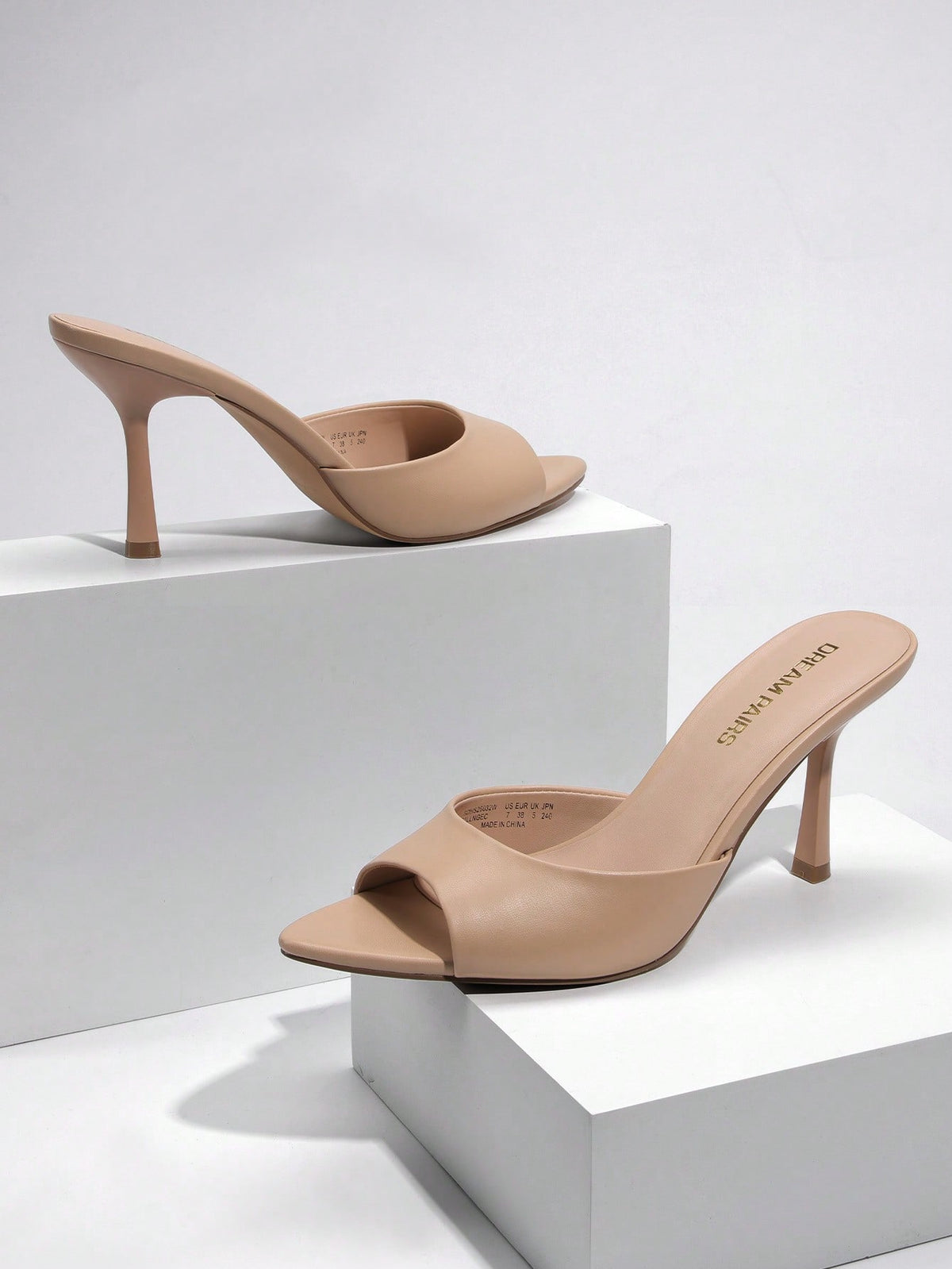 Women's pointed peep toe high heel sandals featuring a sleek stiletto heel, slip-on mule design, and smooth faux leather finish.