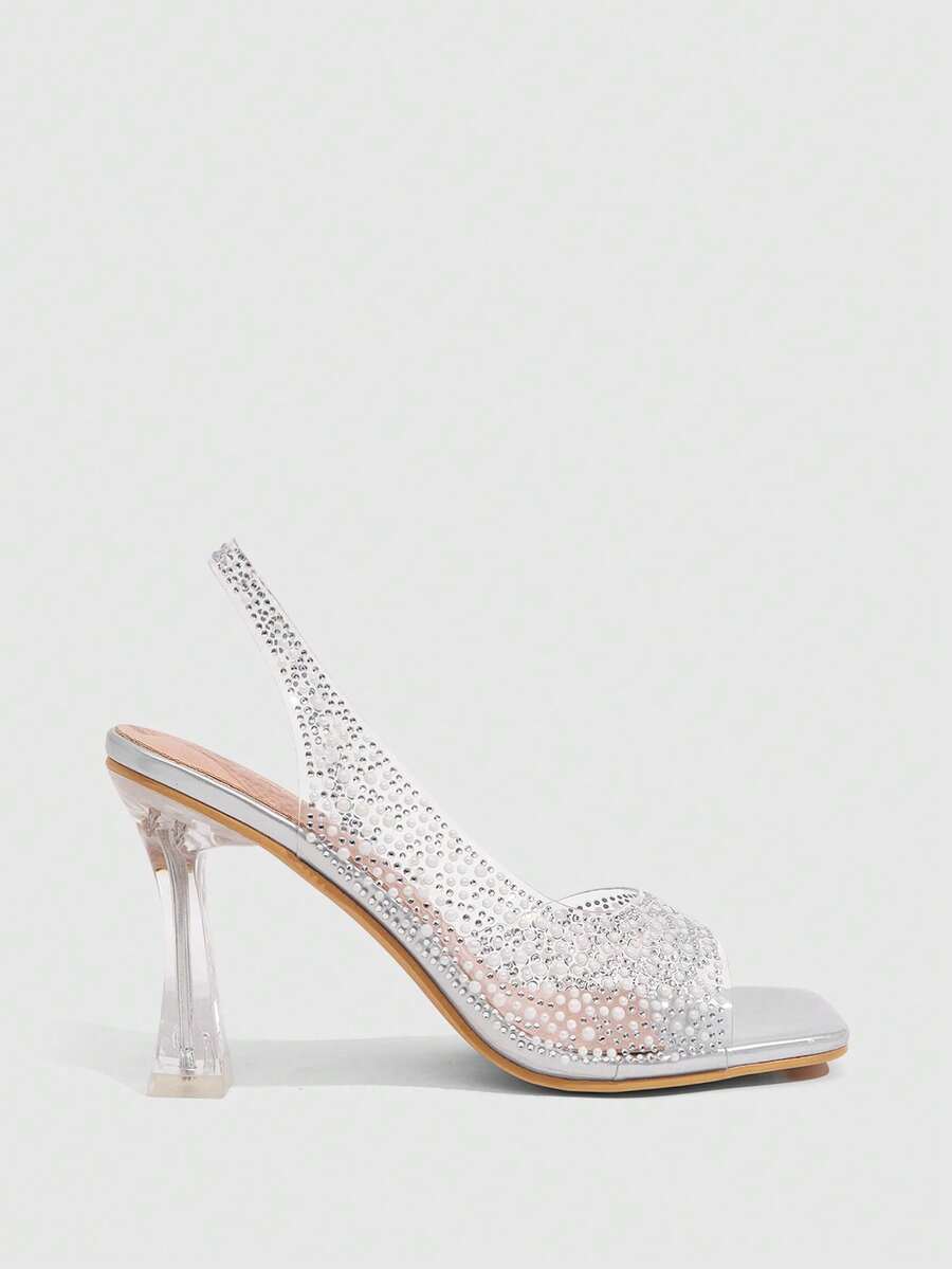 Women's square toe heeled sandals with clear straps, sparkling rhinestone embellishments, and a high pyramid heel.
