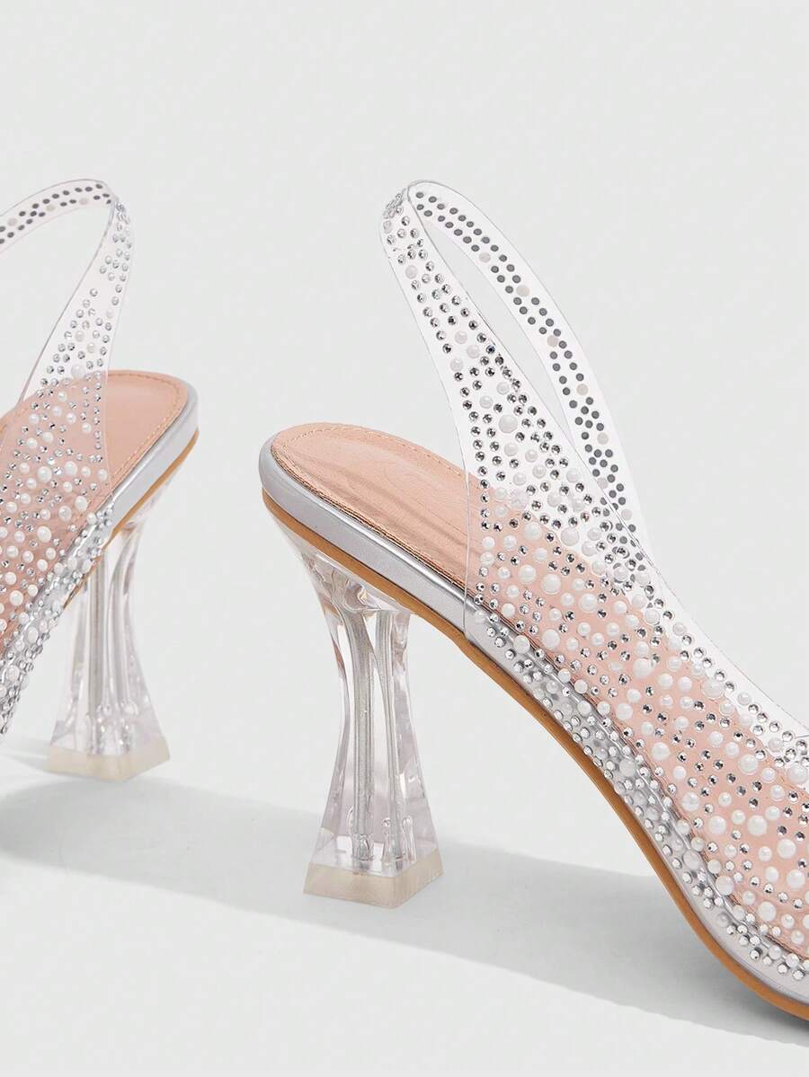 Women's square toe heeled sandals with clear straps, sparkling rhinestone embellishments, and a high pyramid heel.