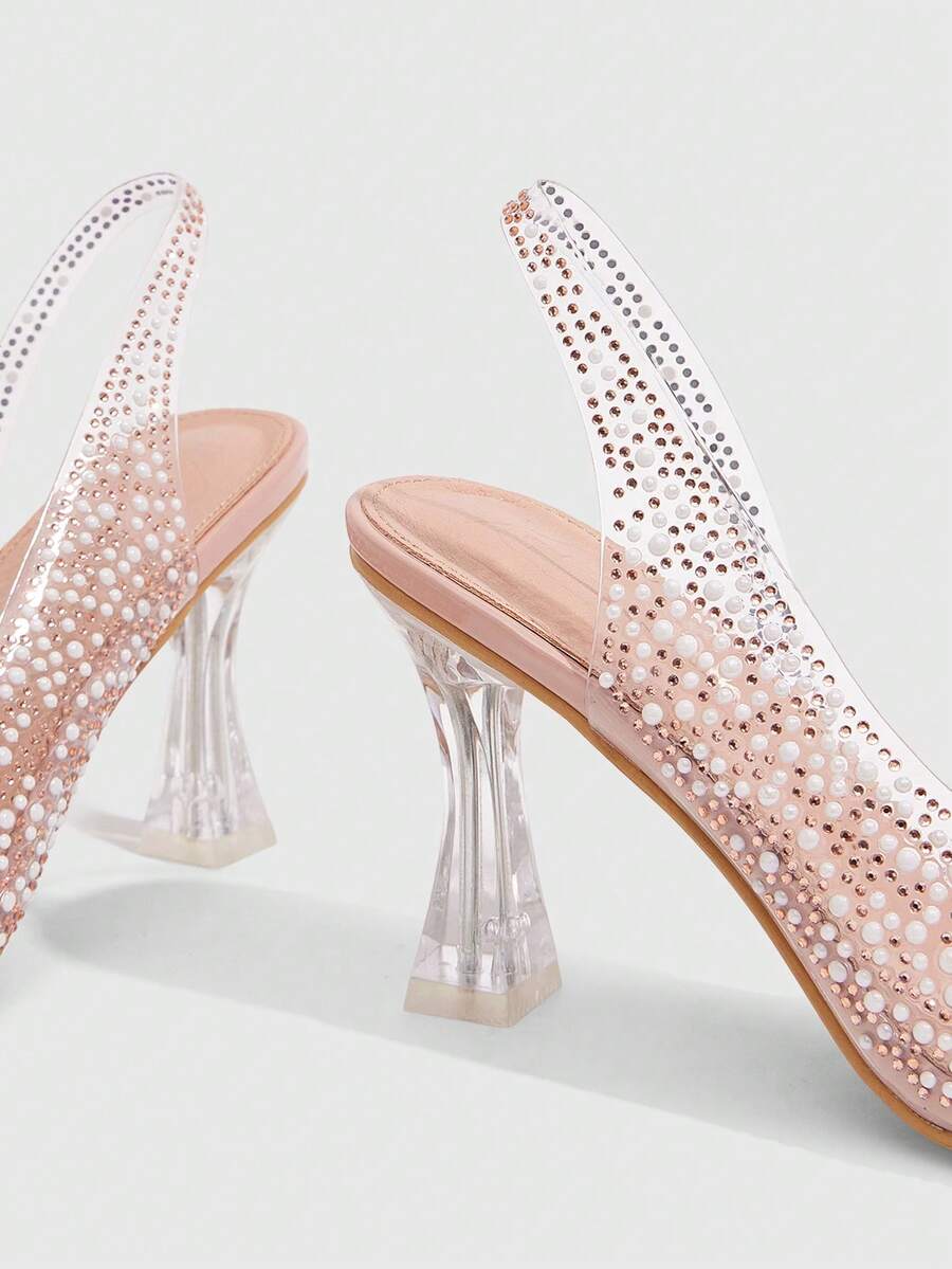 Women's square toe heeled sandals with clear straps, sparkling rhinestone embellishments, and a high pyramid heel.