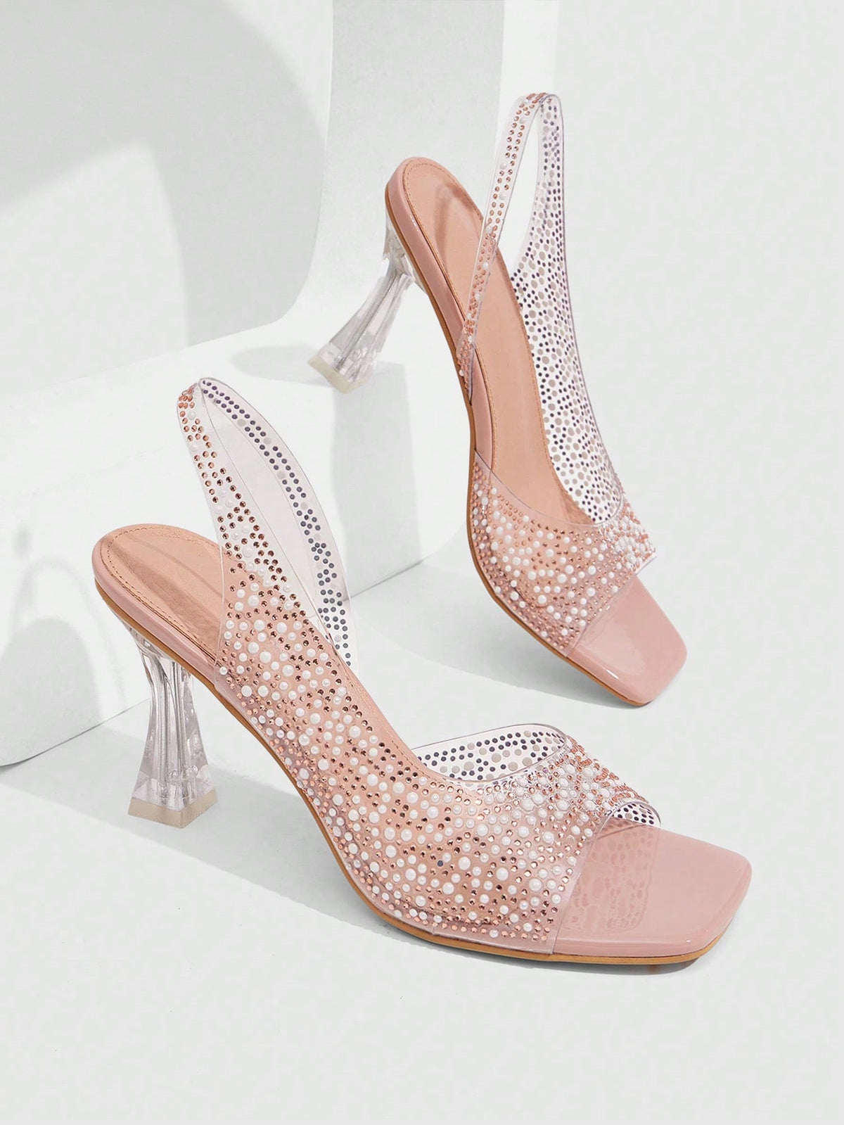 Women's square toe heeled sandals with clear straps, sparkling rhinestone embellishments, and a high pyramid heel.