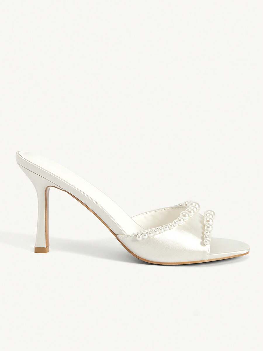 Elegant women's satin high heel sandals with pearl embellishments, stiletto heels, and slingback straps for bridal and wedding wear.