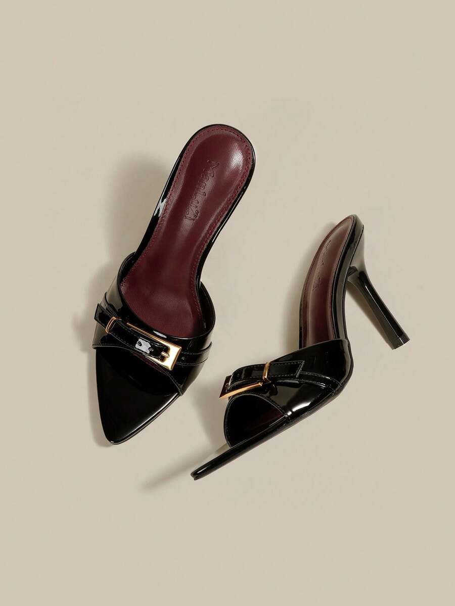 Black patent leather pointed toe mule sandals featuring stiletto high heels and decorative buckle detail for evening parties