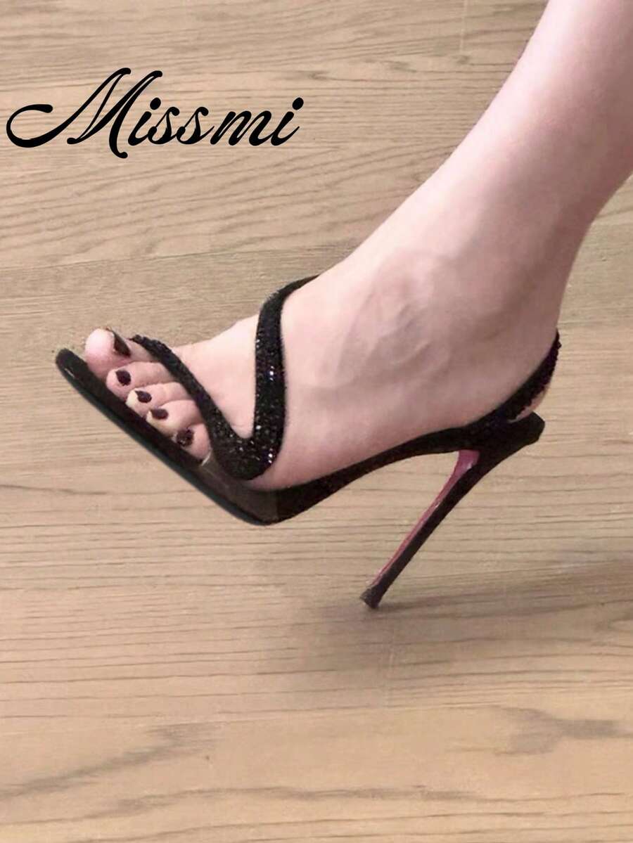 Women's black rhinestone snake design high heel sandals with clear strap, peep toe, and stiletto heel