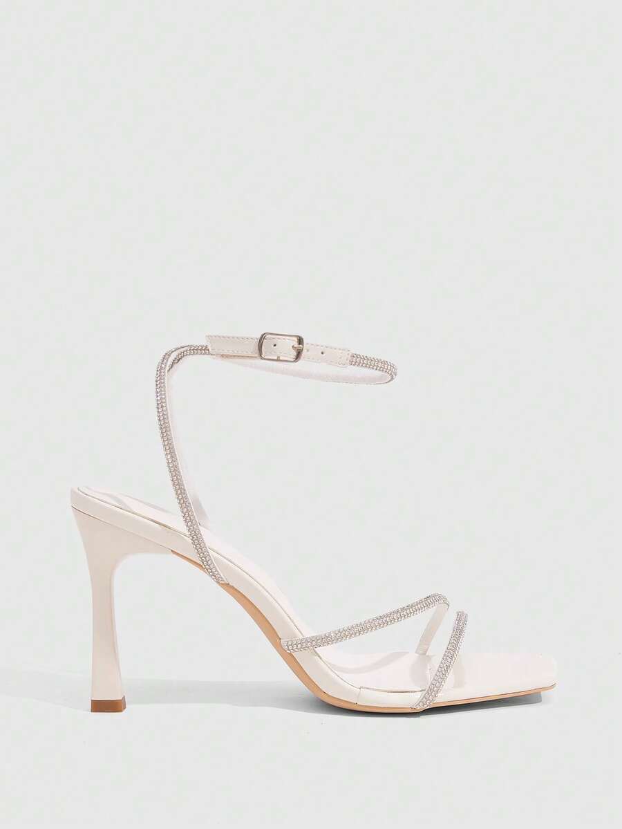 Champagne rhinestone ankle strap heeled sandals with open toe and high stiletto heel for women.