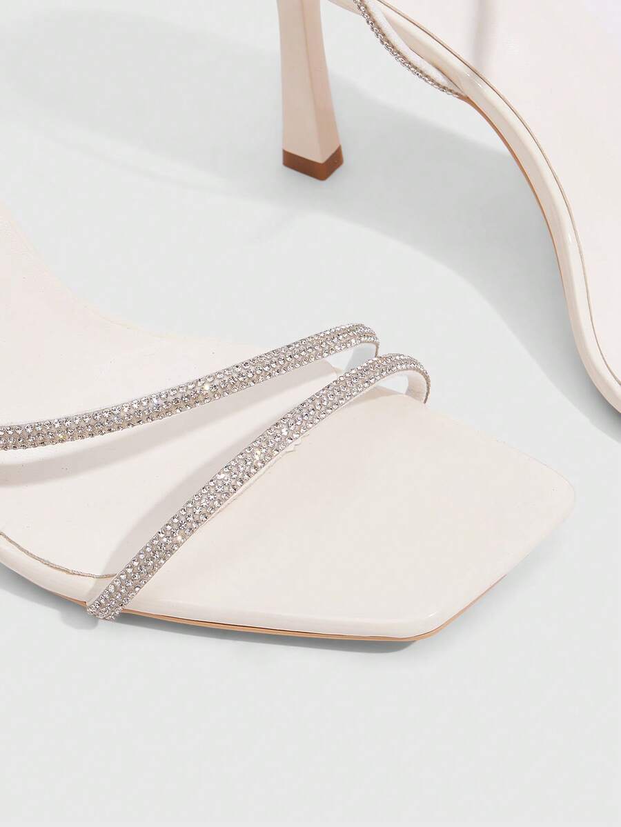 Champagne rhinestone ankle strap heeled sandals with open toe and high stiletto heel for women.